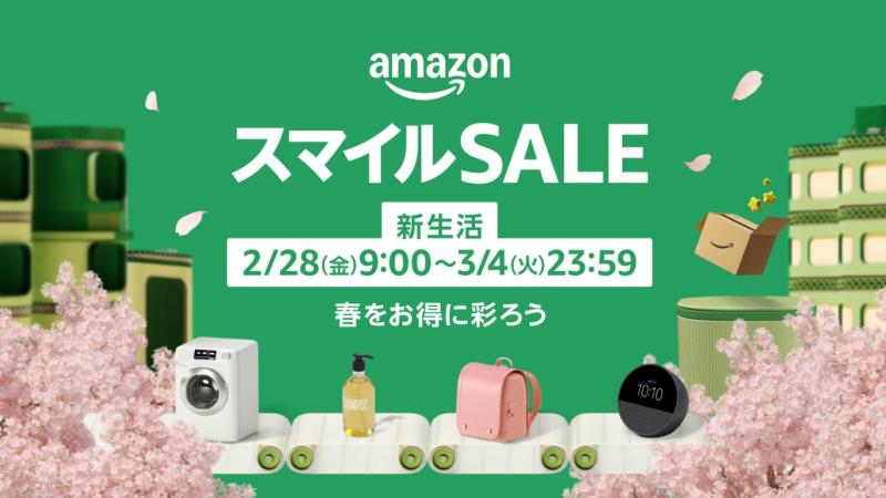 緑色の背景。左右に桜の木と緑色のマンションのような建物の模型。中央上部に「スマイルSALE（スマイルセール）」と「2月28日(金)9時～3月4日(火)23時59分」「春をお得に彩ろう」の文字。その下にピンクのランドセルやドラム式洗濯機などの新生活商品の模型が白いベルトコンベアに載っている